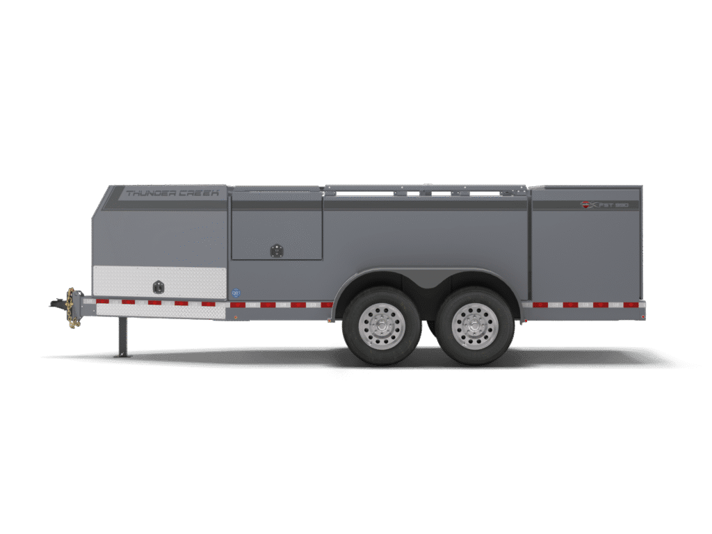 A gray FST Trailer dual-axle utility trailer with storage compartments and red-and-white reflective striping, viewed from the side against a white background.